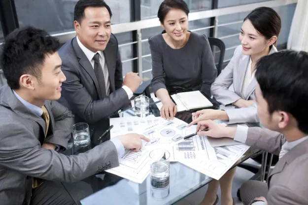 Business professionals collaborating on workflow planning as part of a business process optimisation project led by a project management company.