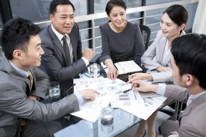 Business professionals collaborating on workflow planning as part of a business process optimisation project led by a project management company.