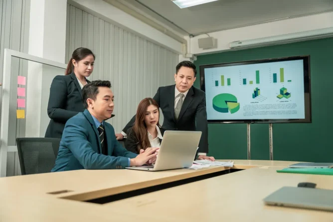 Project management consultancy team reviewing project data and performance metrics in a business meeting