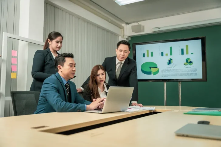 Project management consultancy team reviewing project data and performance metrics in a business meeting