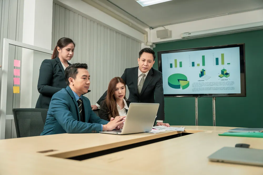 Project management consultancy team reviewing project data and performance metrics in a business meeting